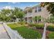 Charming two-story home featuring a manicured lawn, white picket fence, and inviting balconies at 311 1St Sw Ave, Largo, FL 33770