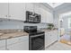 Bright kitchen features white cabinets, granite countertops, stainless steel appliances and tile floors at 311 1St Sw Ave, Largo, FL 33770