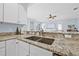 Granite countertop features a stainless steel faucet and sink, with a view into the living room at 311 1St Sw Ave, Largo, FL 33770