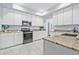 Bright kitchen features white cabinets, granite countertops, stainless steel appliances and tile floors at 311 1St Sw Ave, Largo, FL 33770