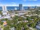 Aerial view of a home location among lush trees with city skyline and waterfront in the distance at 3114 W Granada St, Tampa, FL 33629
