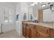 Well-lit bathroom featuring a wooden vanity with marble countertop and a window with plantation shutters at 3114 W Granada St, Tampa, FL 33629