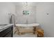 This modern bathroom boasts a freestanding tub with a unique chandelier and sleek fixtures at 3114 W Granada St, Tampa, FL 33629