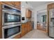 Gourmet kitchen offers stainless steel appliances and black granite countertops and breakfast bar with wood floor leading to other rooms at 3114 W Granada St, Tampa, FL 33629