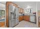 Functional kitchen with stainless steel appliances, wood cabinetry, and tile backsplash with a view to the dining room at 3114 W Granada St, Tampa, FL 33629