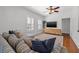 Comfortable living room offering natural light, a plush sectional, and built-in storage with hardwood flooring at 3114 W Granada St, Tampa, FL 33629