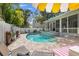 Private backyard with a refreshing pool, a brick patio, and lush tropical landscaping at 3114 W Granada St, Tampa, FL 33629