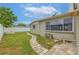 Grassy backyard with a stone walkway, back patio, large picture window and a white privacy fence at 3145 Domino Dr, Holiday, FL 34691