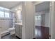 Bathroom with gray vanity, tiled shower, and access to bedroom with hardwood floors at 3145 Domino Dr, Holiday, FL 34691