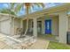 Inviting front porch featuring a blue door, neutral paint, and manicured landscaping at 3145 Domino Dr, Holiday, FL 34691