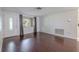 Living room featuring hardwood floors, a white front door, and a window with curtains at 3145 Domino Dr, Holiday, FL 34691