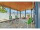 Covered patio area with tiled flooring, fan, privacy fence and various chairs and greenery for relaxing outdoors at 3145 Domino Dr, Holiday, FL 34691