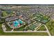 Aerial view showcasing the community's clubhouse, pool, tennis and bocce ball courts, and surrounding neighborhood at 31921 Magna Gulf Loop, San Antonio, FL 33576