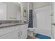 Bathroom featuring a granite countertop, white vanity, skull themed shower curtain, and bathtub combination at 31921 Magna Gulf Loop, San Antonio, FL 33576