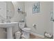Stylish powder room with pedestal sink, toilet, and coastal-themed decor at 31921 Magna Gulf Loop, San Antonio, FL 33576