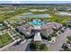 An aerial view shows a clubhouse with a pool, parking, and manicured landscaping at 31921 Magna Gulf Loop, San Antonio, FL 33576