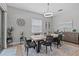 Elegant dining room with a large wooden table, gray chairs, modern light fixture and stylish décor at 31921 Magna Gulf Loop, San Antonio, FL 33576