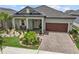 Charming home exterior with a well-manicured lawn, a paver driveway, and a cozy front porch at 31921 Magna Gulf Loop, San Antonio, FL 33576