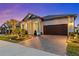 Stunning home exterior with a paver driveway, manicured landscaping, and a covered entry at 31921 Magna Gulf Loop, San Antonio, FL 33576