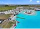 Overhead view of the lagoon with beach seating, umbrellas, inflatable slides, and beachside dining at 31921 Magna Gulf Loop, San Antonio, FL 33576