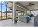 Relaxing screened lanai offers outdoor seating, a ceiling fan, and a view of the lush, landscaped backyard at 31921 Magna Gulf Loop, San Antonio, FL 33576