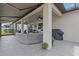 Covered lanai featuring outdoor seating, ceiling fans, and an outdoor grill, perfect for entertaining guests at 31921 Magna Gulf Loop, San Antonio, FL 33576