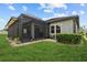 Covered lanai with stylish pavers is adjacent to a manicured yard with planted bushes at 31921 Magna Gulf Loop, San Antonio, FL 33576