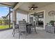 Outdoor seating area with four chairs and a table, with view from inside the lanai through sliding doors to the dining area at 31921 Magna Gulf Loop, San Antonio, FL 33576