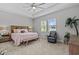 Spacious main bedroom featuring tray ceilings, a ceiling fan, and large windows at 31921 Magna Gulf Loop, San Antonio, FL 33576