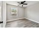 This bedroom features modern gray floors, light gray walls, white trim, ceiling fan and a window with a view at 3515 41St S Ter # 224, St Petersburg, FL 33711