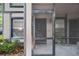 A screened front porch, featuring a black front door and manicured landscaping at 4004 Dream Oak Pl # 102, Tampa, FL 33613