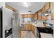 A functional kitchen features wood cabinetry, stainless appliances, and efficient layout at 4004 Dream Oak Pl # 102, Tampa, FL 33613