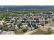 An aerial view of a neighborhood featuring single-Gathering homes, mature trees, and community lakes at 403 Carriage House Ln, Tarpon Springs, FL 34688