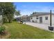 Well-maintained backyard featuring paved patio, lawn, and screened pool enclosure at 403 Carriage House Ln, Tarpon Springs, FL 34688