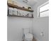 Bright bathroom featuring a toilet, floating shelves, and natural light from a window at 403 Carriage House Ln, Tarpon Springs, FL 34688