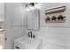Well-lit bathroom featuring a modern vanity, stylish mirror and floating shelves at 403 Carriage House Ln, Tarpon Springs, FL 34688
