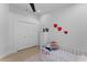 Light and airy bedroom with a crib, closet, and playful ladybug wall decorations at 403 Carriage House Ln, Tarpon Springs, FL 34688