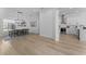 Bright dining area boasts modern lighting, table, and chairs, flowing into the kitchen with white cabinets at 403 Carriage House Ln, Tarpon Springs, FL 34688
