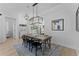 Open-concept dining area with wood floors, modern chandelier, and a view to the front entrance and living room at 403 Carriage House Ln, Tarpon Springs, FL 34688