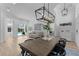 Open-concept dining room with wood floors, modern lighting, and views to the pool, lanai, and living area at 403 Carriage House Ln, Tarpon Springs, FL 34688