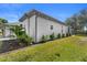 Well-maintained yard with lush landscaping along the side of the home, and a glimpse of an enclosed lanai at 403 Carriage House Ln, Tarpon Springs, FL 34688