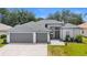 Beautiful single-story home featuring a three-car garage, well-maintained lawn, and neutral color palette at 403 Carriage House Ln, Tarpon Springs, FL 34688