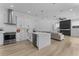 Open-concept kitchen featuring white cabinets, stainless steel appliances, and a view of the living room at 403 Carriage House Ln, Tarpon Springs, FL 34688