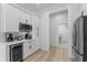 Bright kitchen with white cabinetry, stainless steel refrigerator, and wine cooler at 403 Carriage House Ln, Tarpon Springs, FL 34688