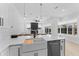 Bright, modern kitchen features a center island, white cabinetry, and adjacent living space with pool views at 403 Carriage House Ln, Tarpon Springs, FL 34688