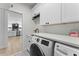 Convenient laundry room with modern washer and dryer, cabinetry, and elegant tile flooring at 403 Carriage House Ln, Tarpon Springs, FL 34688