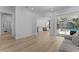 Bright and airy living room featuring wood flooring, neutral walls, and a view of the pool through sliding glass doors at 403 Carriage House Ln, Tarpon Springs, FL 34688