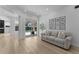 Comfortable living room with wood floors, a gray sofa, and sliding glass doors to the lanai and pool at 403 Carriage House Ln, Tarpon Springs, FL 34688