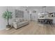 Bright and spacious living area with wood floors, a comfortable gray sofa, and an open flow to the dining area at 403 Carriage House Ln, Tarpon Springs, FL 34688