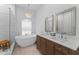 Elegant main bathroom with dual sinks, soaking tub, walk-in shower, and stone tile floors at 403 Carriage House Ln, Tarpon Springs, FL 34688